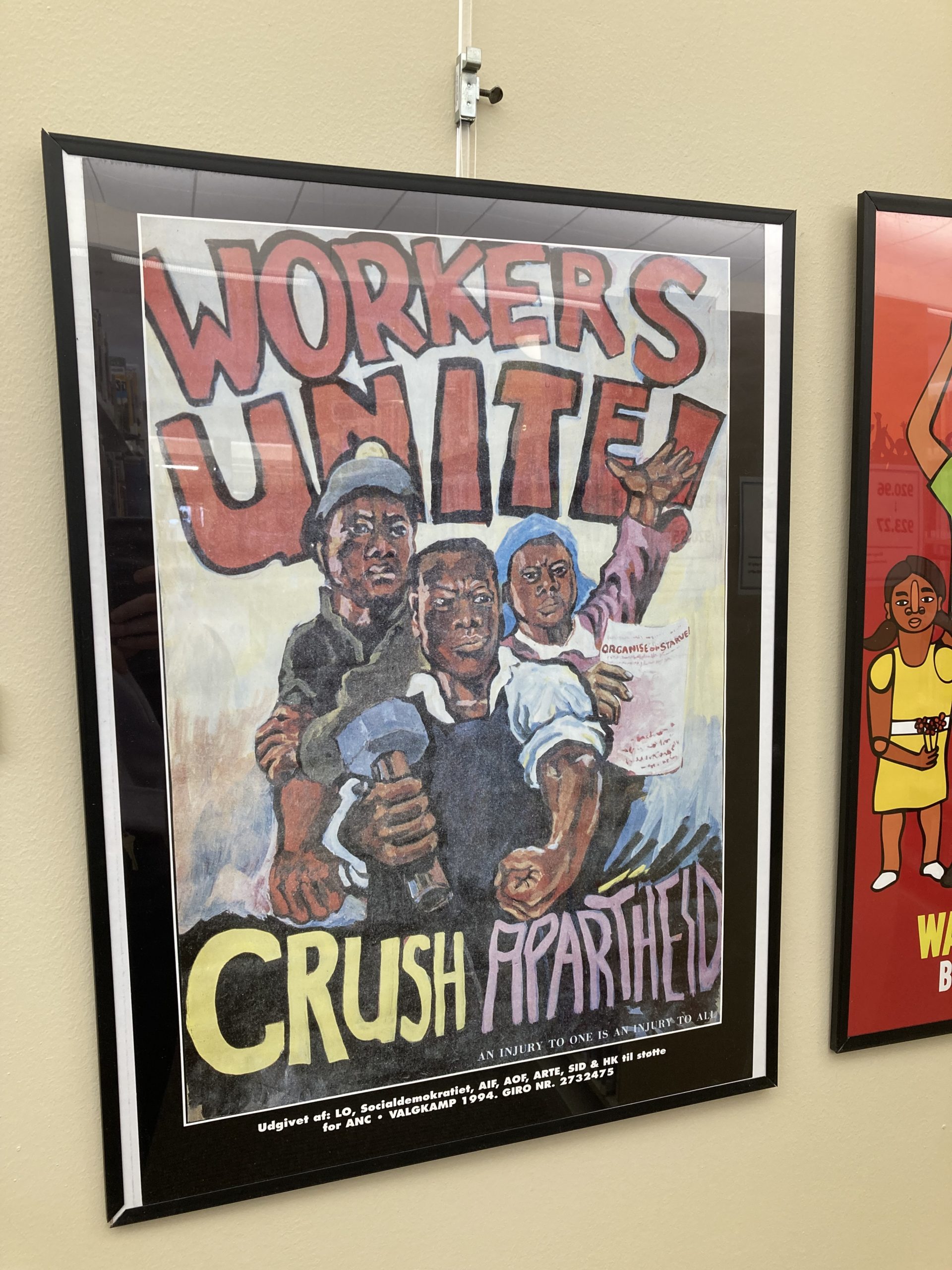 Poster of strong men with title Workers Unite Crush Apartheid